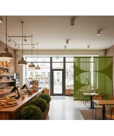 Cloisons acoustiques Flow vertes suspendues dans un café au design naturel et lumineux.