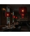 Luminaires acoustiques Iluro rouges suspendus dans un restaurant élégant à l’ambiance feutrée.