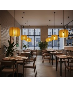 Luminaires acoustiques Iluro jaunes suspendus dans un restaurant moderne au style chaleureux et naturel.